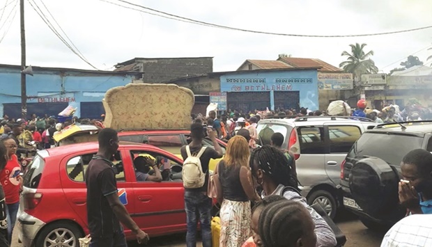People walk amid traffic near the site where a high-tension power cable snapped and fell on houses and a market on the outskirts of Kinshasa, the Democratic Republic of the Congo yesterday, in this still image taken from video obtained from social media.