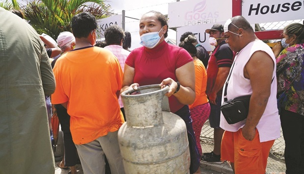 A woman carries a refilled gas container in the centre of the capital Nukuu2019alofa ahead of the countryu2019s first lockdown yesterday, after Covid-19 was detected in the previously virus-free Pacific kingdom as it struggles to recover from the deadly January 15 volcanic eruption and tsunami.