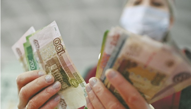 A vendor counts Russian rouble banknotes at a market in Omsk, Russia. The Russian central bank beefed up the banking sector with extra liquidity and started to sell foreign currency on the forex market after the rouble fell to all-time lows on the day Moscow sent its troops into Ukraine.