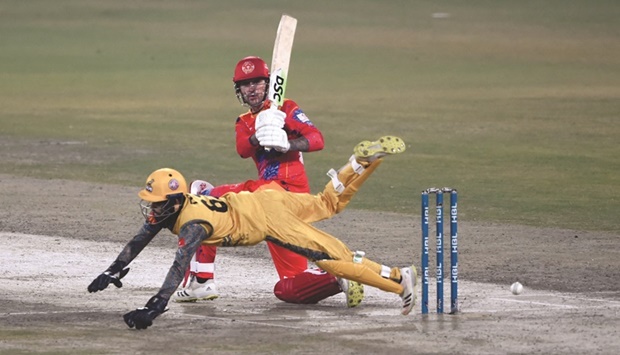 Islamabad Unitedu2019s Alex Hales plays a shot as Peshawar Zalmiu2019s wicketkeeper Mohamed Haris dives during the Pakistan Super League match in Lahore yesterday. (AFP)