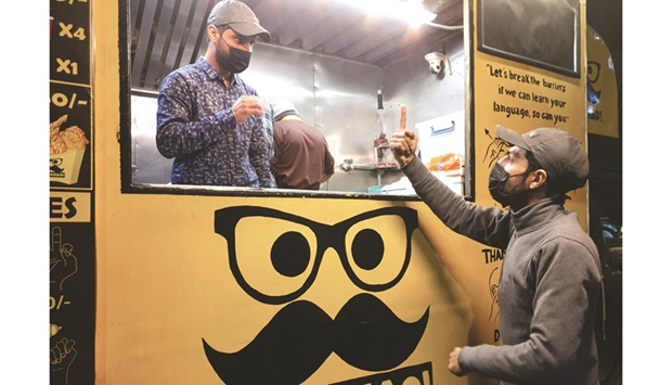 People communicate using sign language at Pakistanu2019s first mobile restaurant staffed entirely by deaf workers, in Islamabad.