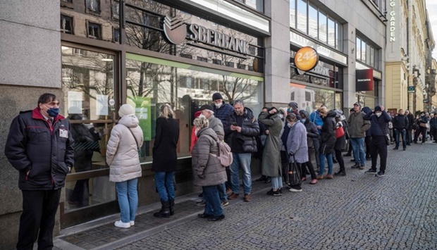 People queue outside a branch of Russian state-owned bank Sberbank to withdraw their savings and close their accounts in Prague, before Sberbank will close all its branches in the Czech Republic later in the day. AFP