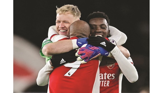 Arsenalu2019s Alexandre Lacazette celebrates with Eddie Nketiah (right) and Aaron Ramsdale (left) after their victory over Wolverhampton Wanderers in London. (Reuters)