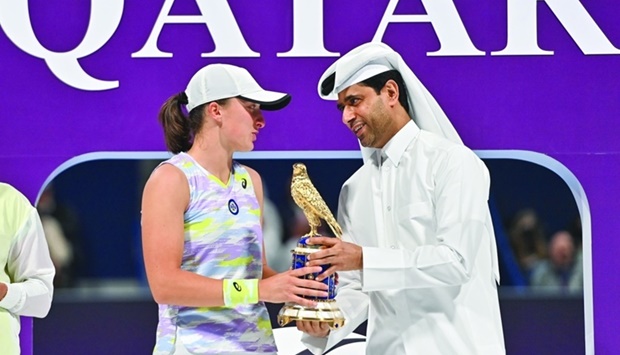 Nasser al-Khelaifi (R), president of the Qatar Tennis Federation, Paris Saint-Germain FC, and chairman of beIN Media Group, presents Iga Swiatek (L) of Poland with the winner's trophy after the final match of the 2022 WTA Qatar Open in Doha on February 26, 2022.
