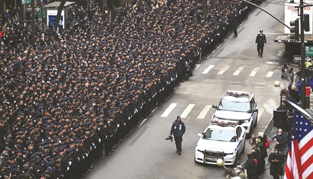 Police officers stand at attention ahead of the processional of fallen officer Wilbert Mora at St Patricku2019s Cathedral yesterday in New York City. (AFP)