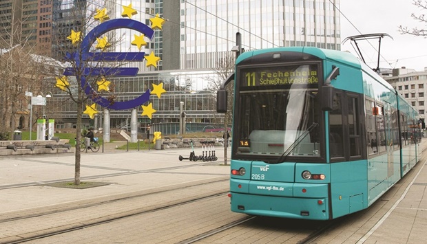 The euro currency sign is seen in front of the former ECB building as a tramway drives past, in Frankfurt am Main on Thursday. The European Central Bank stuck to its ultra-loose monetary policy on Thursday, despite record inflation in the eurozone putting the Frankfurt-based institution under mounting pressure.