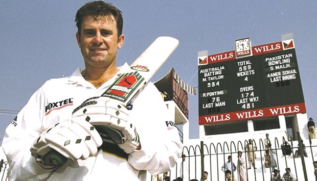 This file photo taken on October 16, 1998 shows Australian captain Mark Taylor raising his bat in front of the  scoreboard at Arbab Niaz Stadium in Peshawar where he scored an unbeaten 334 against Pakistan. Cricket  Australia yesterday confirmed they will tour Pakistan next month for their first official Test tour since 1998.