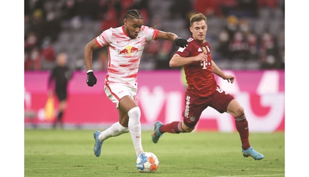 RB Leipzigu2019s Christopher Nkunku (left) vies for the ball with Bayern Munichu2019s Joshua Kimmich during the Bundesiga match at the Allianz Arena in Munich yesterday. (Reuters)