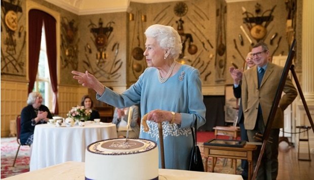 Britain's Queen Elizabeth II cuts a cake to celebrate the start of the Platinum Jubilee during a reception in the Ballroom of Sandringham House, the Queen's Norfolk residence. Joe Giddens / POOL / AFP