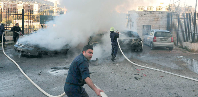 Firefighters douse burning cars near the Sheraton Hotel in Damascus. 