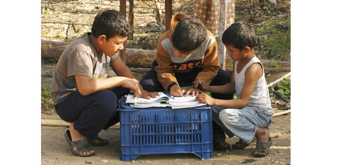 Boys do homework at a UNHCR camp for Syrian refugees in south Lebanon.