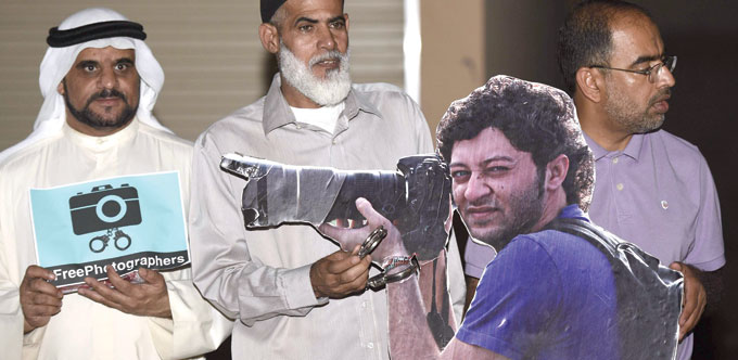 Activists carry placards during a rally supporting jailed photojournalist Ahmed Humaidan near his home in Sitra island, south of Manama on Saturday. 