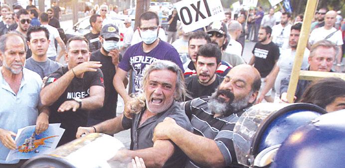 Demonstrators scuffle with police outside the parliament in Nicosia.  The placards read u2018Nou2019.