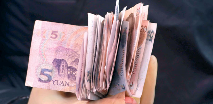 Yuan bank notes are seen in a vendoru2019s hand at a market in Beijing. The Chinese currency closed at 6.1939 to the dollar, a record high yesterday.