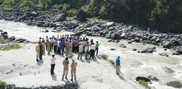 Rescue personnel gather on the banks of the Beas river during a search operation in Kullu, Himachal Pradesh yesterday.