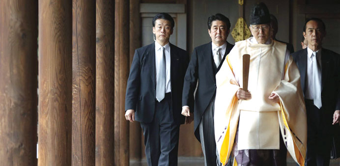 Japanu2019s Prime Minister Shinzo Abe  being led by a Shinto priest as he visits Yasukuni shrine in Tokyo in  December last year. China associates the  Ya