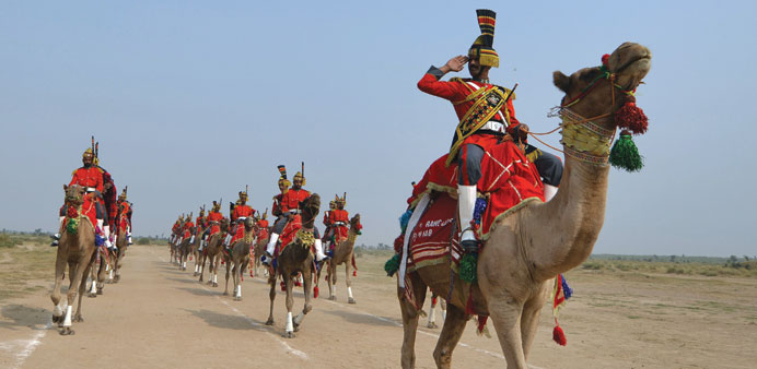 Band Major of Pakistan Desert Rangers, Mohamed Iqbal (right) salutes as he conducts team members mounted on camels during a march in Moj Garh, some 10