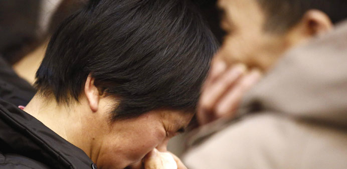 A mother of a passenger on board the missing Malaysia Airlines flight MH370 crying as she listens to a briefing from the airline company at a hotel in