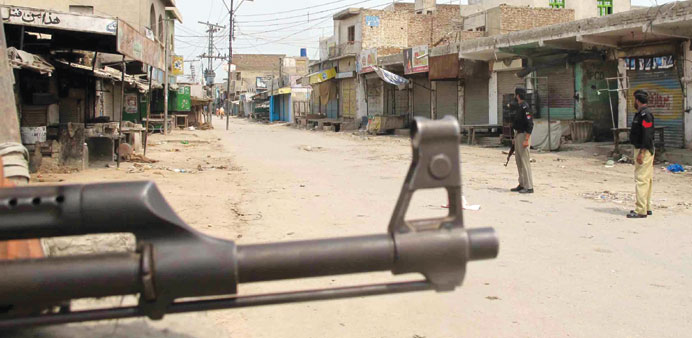 Pakistani police stands guard at a check point as authorities imposed a curfew after the district jail was attacked by Islamic militants, in Dera Isma