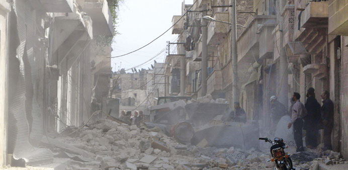 People stand at a site hit by what activists said was an air raid by regime forces in Aleppo yesterday.