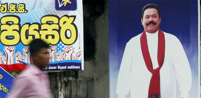 A man walks past a poster of Sri Lanka's former president Mahinda Rajapaksa