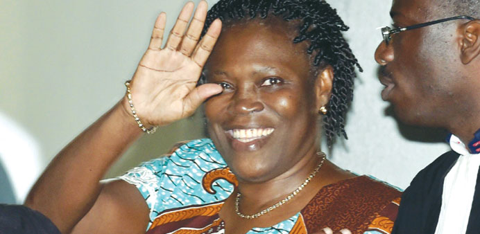 Ivory Coastu2019s former first lady Simone Gbagbo waves as she arrives at the Court of Justice in Abidjan.