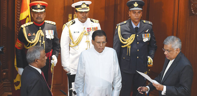 Sri Lankau2019s newly-elected Prime Minister Ranil Wickremesinghe takes oath as he is sworn before Sri Lankan President Maithripala Sirisena during a cere