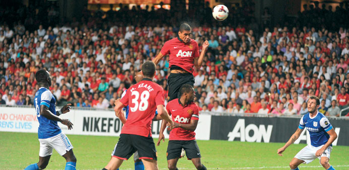 Manchester Unitedu2019s Chris Smalling (top C) heads the ball towards goal against Hong Kong team Kitchee during their football friendly match at Hong Kon