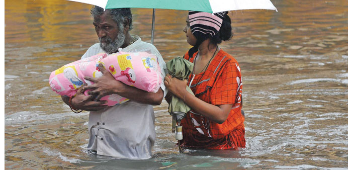  A family wades through floodwaters in Chennai yesterday.