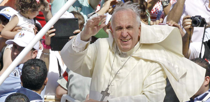 Pope Francis waves to pilgrims upon his arrival at Amman International Stadium where he celebrated a mass yesterday.