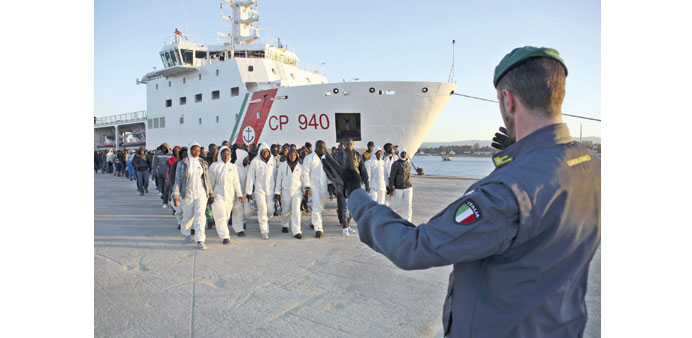  Migrants from a Coast Guard boat follow instructions after disembarking yesterday in the Sicilian harbour of Augusta.