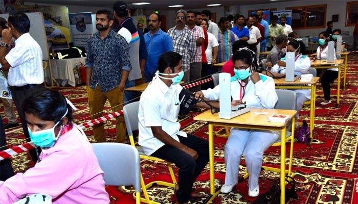 Workers get tested for blood pressure at the medical camp..