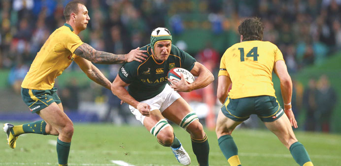 Juandre Kruger (C) from South Africa breaks between Australiau2019s Quade Cooper (L) and Adam Ashley-Cooper (R) during the Rugby Championship 2013 test ma