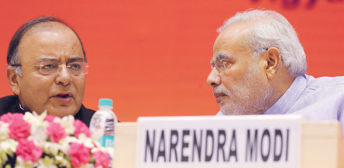 Prime Minister Narendra Modi speaks with Finance and Defence Arun Jaitley at the launch of a scheme to open bank accounts for millions of people in Ne