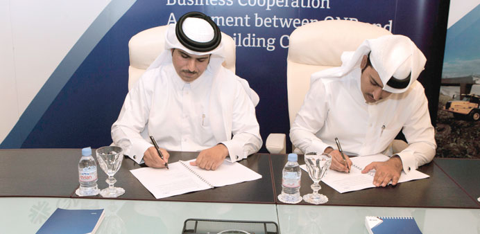 QNB and QBC officials signing a deal.