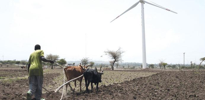 A farmer ploughs his land near a turbine of the Adama wind farm, south of Addis Ababa.