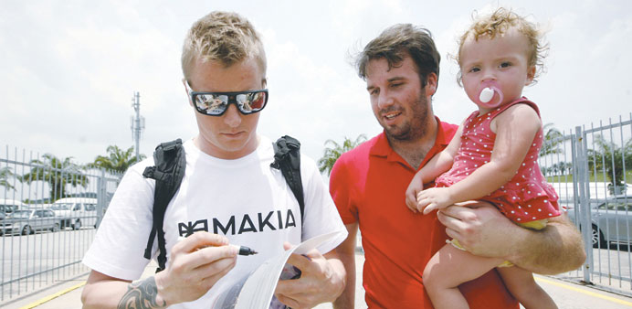 Lotus Formula One driver Kimi Raikkonen signs an autograph as he arrives at Sepang circuit outside Kuala Lumpur yesterday. (Reuters)