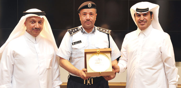 Brigadier Al-Kharji, flanked by Dr Al-Khalifa, left, and Dr Al-Ammari, shows off an award plaque.