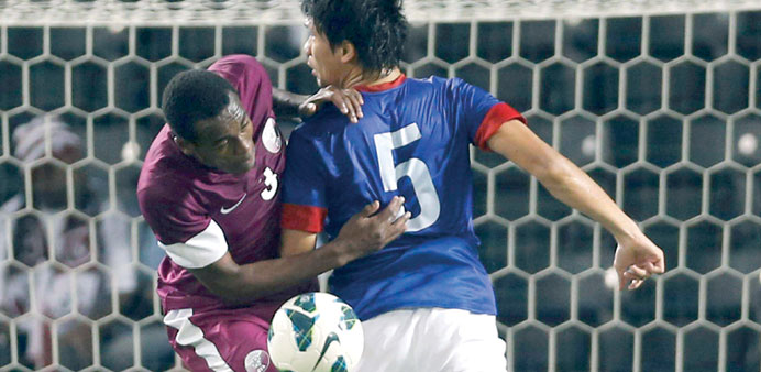 Qataru2019s Abdulkareem Hassan (L) fights for the ball with Malaysiau2019s Mohamad Aidil Zafuan during their 2015 AFC Asian Cup qualifying soccer match in Doh