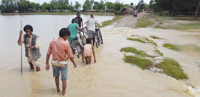 Nepalese villagers walk through floodwaters in Banke district some 350km west of Kathmandu.