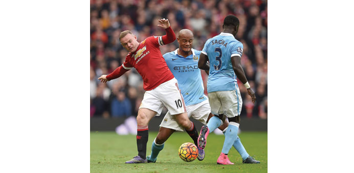 Manchester Unitedu2019s Wayne Rooney (L) is challenged by Cityu2019s Belgian defender Vincent Kompany (C). 