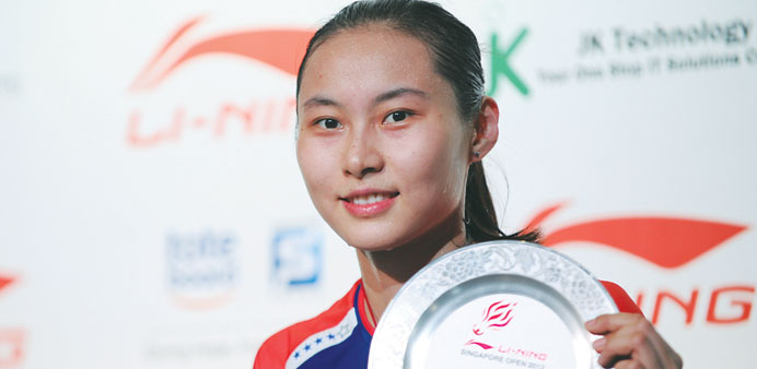 Chinau2019s Wang Yihan poses with the plaque after defeating compatriot Li Xuerui in the womenu2019s singles final at the Singapore Open yesterday. Wang won 2