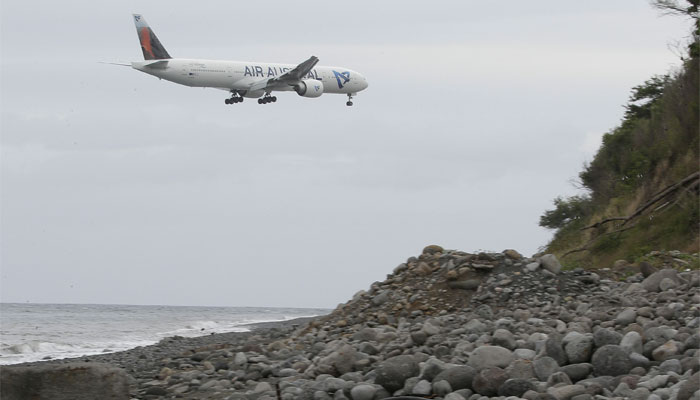 An airplane flies over the Jamaique beach in Saint-Denis on the French Indian Ocean island of La Reunion. AFP