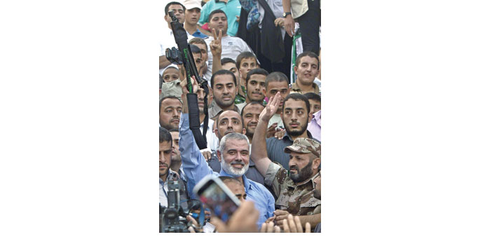 Hamas leader Ismail Haniya brandishes a weapon during a rally in Gaza City yesterday.