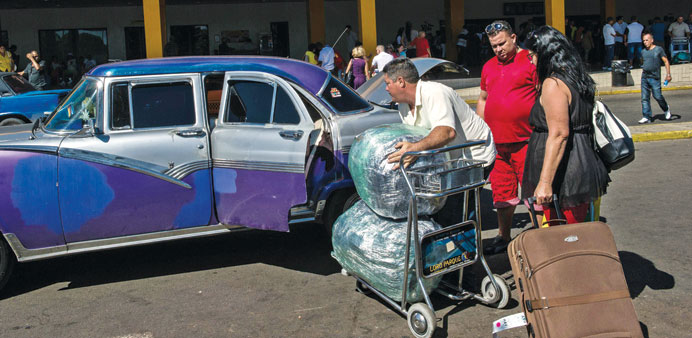 A man puts travellersu2019 bags into a car at the Jose Marti international airport in Havana yesterday.