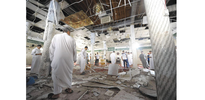 Saudi men gathering around debris inside the mosque after the blast.