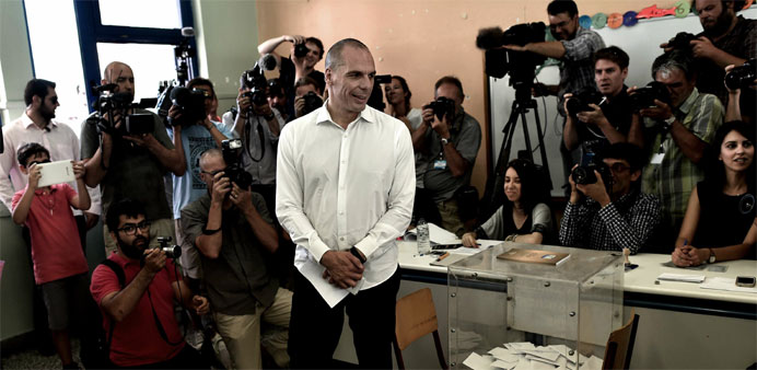 Greek Finance Minister Yanis Varoufakis looks at journalists before casting his ballot 