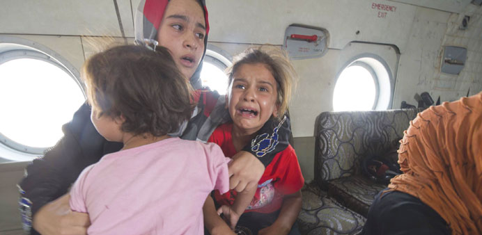A woman and children react in a military helicopter after being evacuated by Iraqi forces from Amerli yesterday.