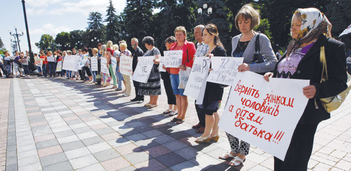 Relatives of men drafted into the army hold placards to demand their return during a rally near the Verkhovna Rada (Ukrainian parliament) building in 