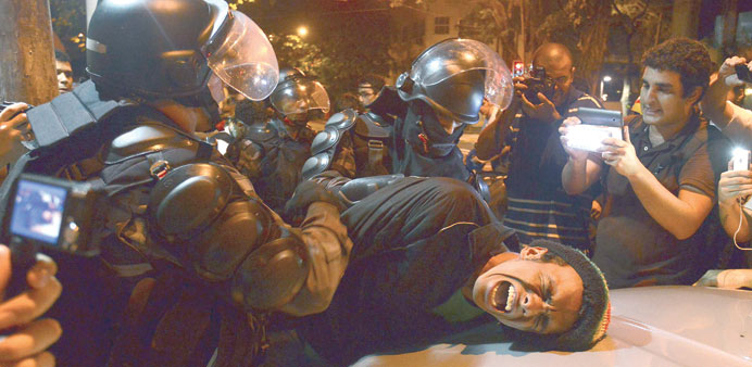 A demonstrator is detained during the protest against Rio de Janeiro Governor Cabral.